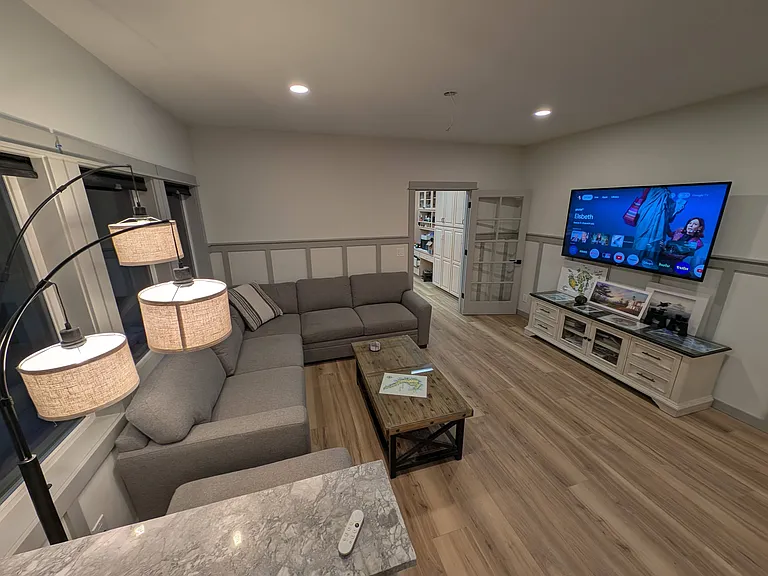 Living room with sectional, coffee table, and wall-mounted TV.