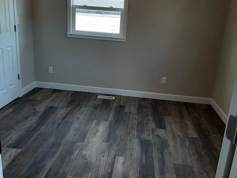 Back bedroom with ceiling fan and closet with light.