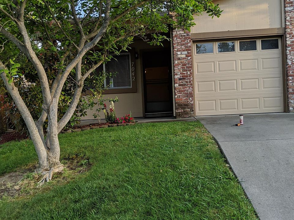 Tulip tree in front yard and spacious garage with remote, space for washer/dryer, storage, and entrance into home