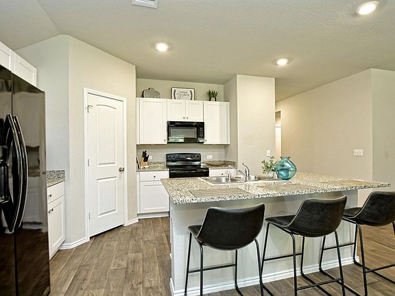 The kitchen has granite countertops, center island/breakfast bar and recessed lighting.