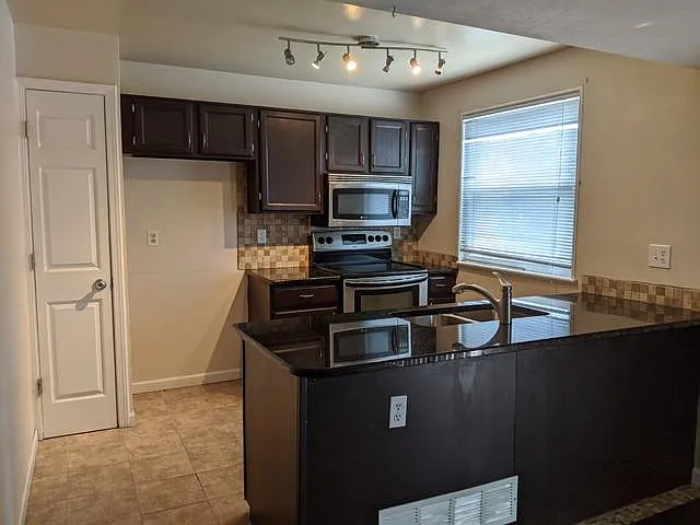 Kitchen with pantry and Stainless Steel Appliances. Updated cabinets/hardware, tile backsplash and granite countertops all 3 years ago.