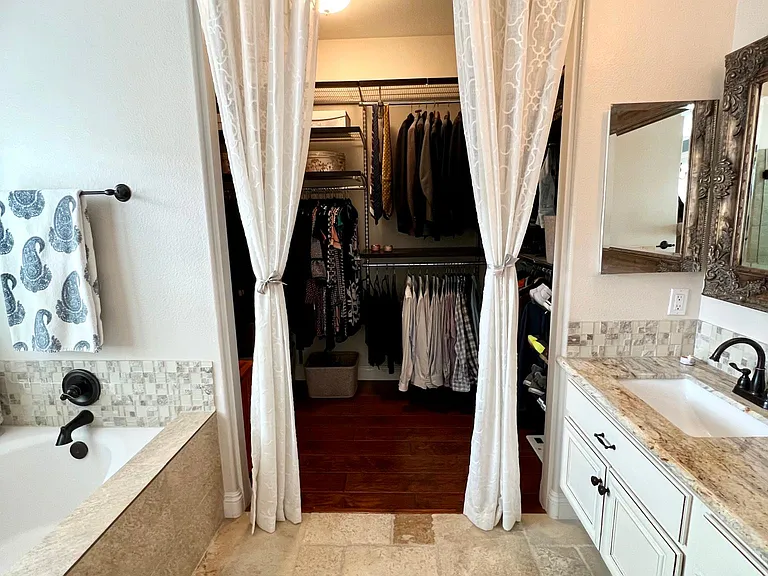 Master bathroom with view of large custom master closet
