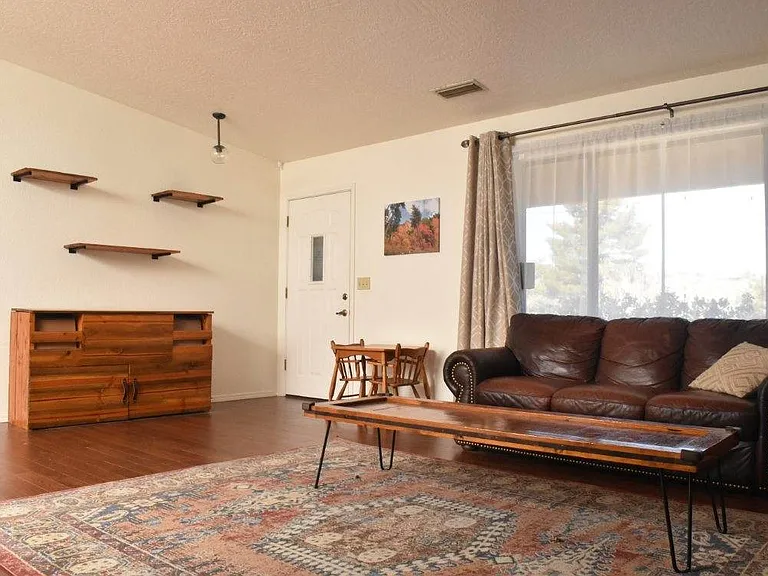 Couch, shelves, and front entrance.