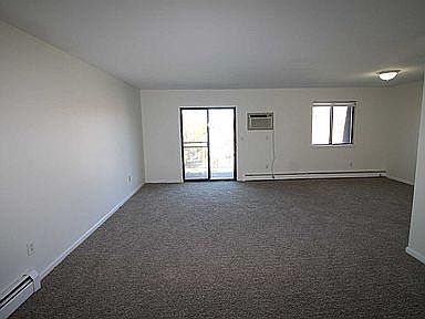 Large Livingroom with new carpets recently installed with a glass sliding door leading to Balcony.