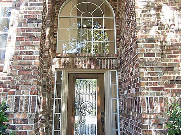Impressive two story porch features paladium window and beveled glass door.