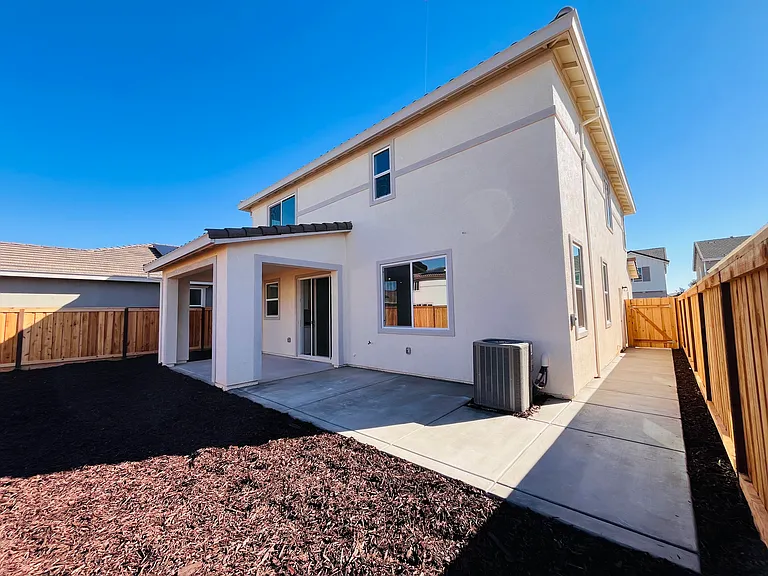 Backyard with extended concrete area and side yard pathways