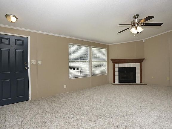 Alternate living area view, featuring fireplace and ceiling fan