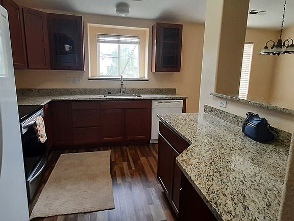 Warm tones, brand new granite countertop & new glass front cabinets plus a lovely island in this spacious kitchen.