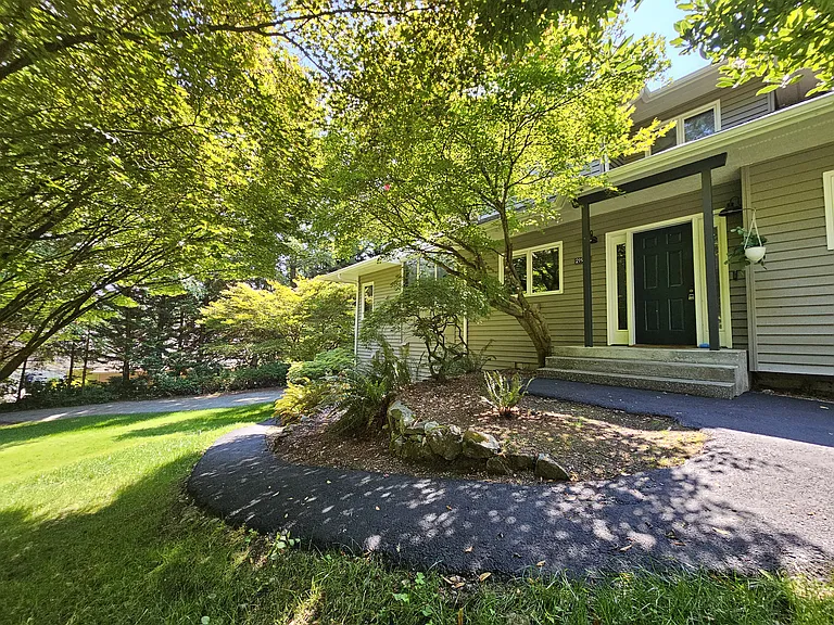 Front door with paved access to lower portion of the home and garages.
