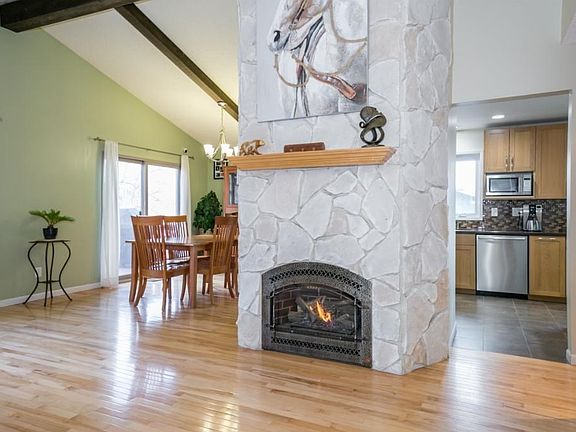 True hardwood floors in the upper main level. Lovely living area with tons of natural light shining through the large windows. The custom gas fire place is a definite focal point.