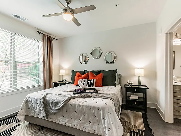 Primary Bedroom With Queen Size Bed, View of Window & Bathroom Entrance