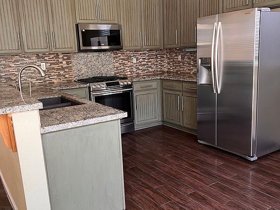 Fully functional kitchen with Samsung chef collection cooking range, microwave and refrigerator. Breakfast nook in the kitchen with double sliding doors to backyard.