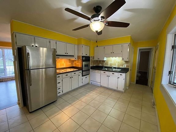 Large eat in kitchen with stainless steel appliances.