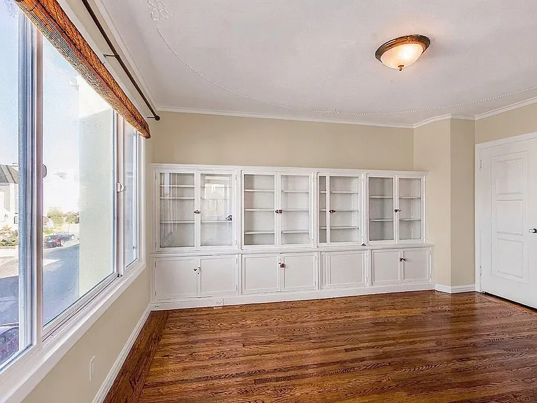 1 of 4 bedrooms with period built-in wall of cabinets, glass door access to 2nd floor deck and closet. House will be delivered unfurnished.