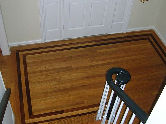 Large foyer showcases custom designed hardwoods