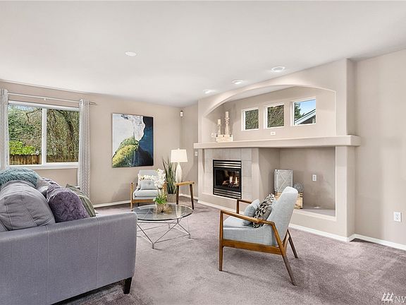 Living room with natural gas fireplace surrounded by built-in alcove.