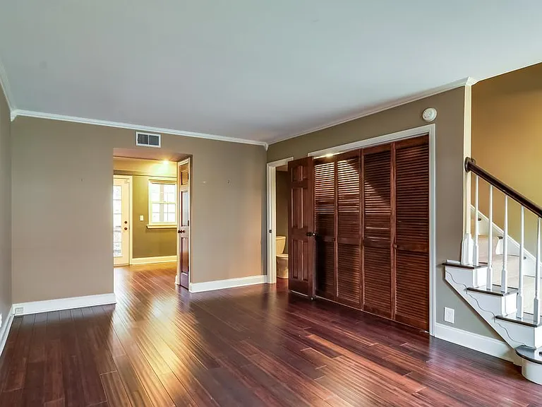 Living area with kitchen in background, half bath on right