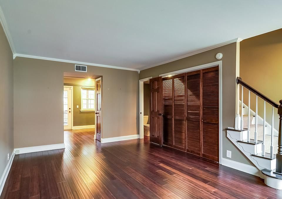 Living area with kitchen in background, half bath on right
