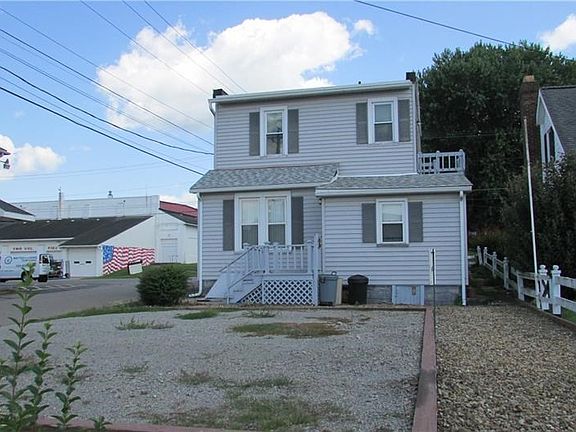 Exterior back of the triplex with parking for 4 cars.