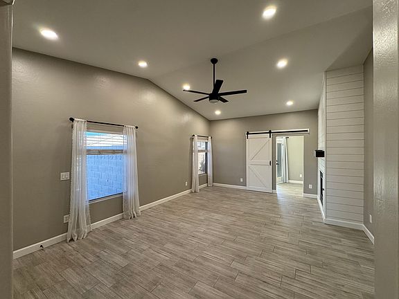 Living room with barn door leading into den/office area