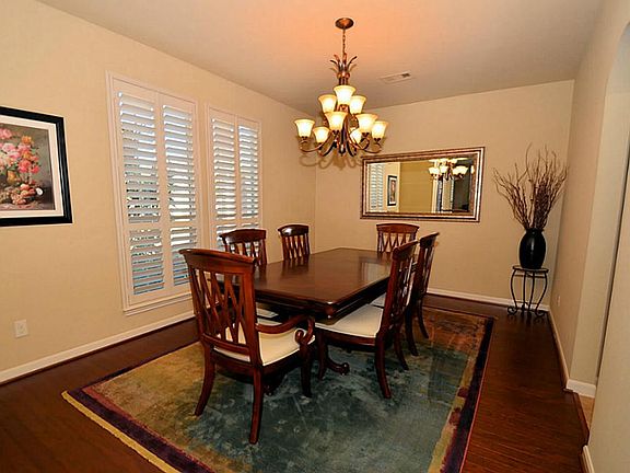 Dining room has wood floors and plantation shutters