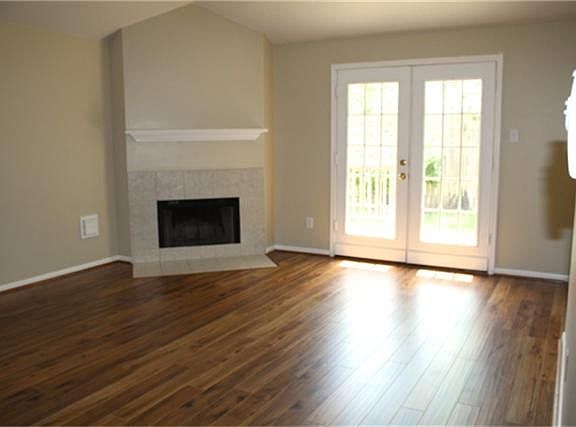Living area has fireplace with attractive tile surround and soaring Gambrel ceiling.