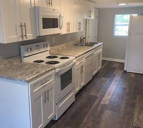 New ceiling lights, shaker cabinets, countertops, hardware, sink, garbage disposal, and Whirlpool appliances: Refrigerator, stove, microwave, and dishwasher