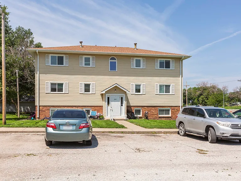 Parking lot and front exterior of Ashland Park Apartments.