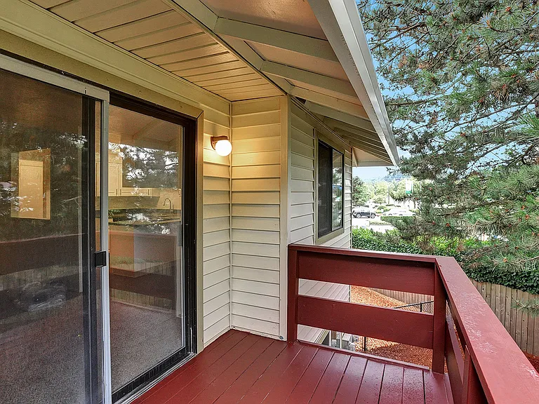 a deck with a red railing and a sliding glass door Foothills Apartments Portland OR