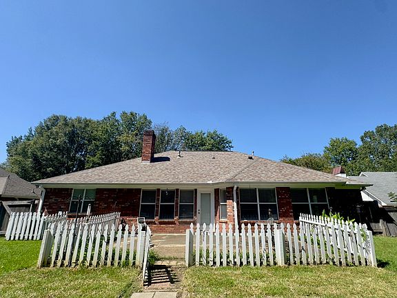 Back view of the Home with picket fence around patio