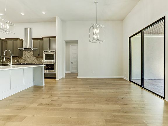 The dining area has designer lighting and quick access to the kitchen.