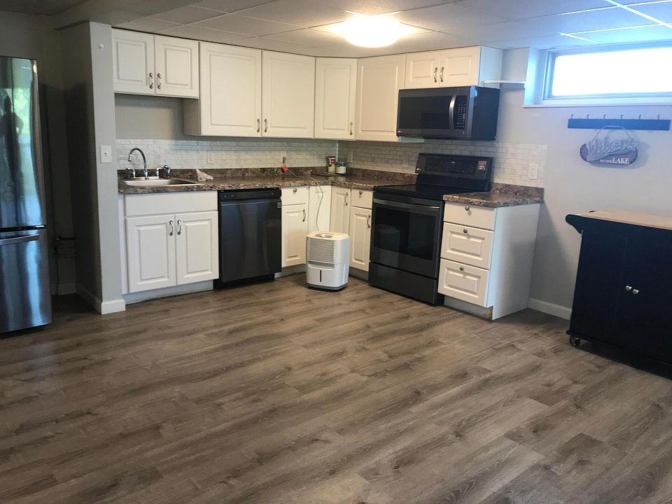 Open area showing kitchen with new appliances including stove, frig, dishwasher, microwave