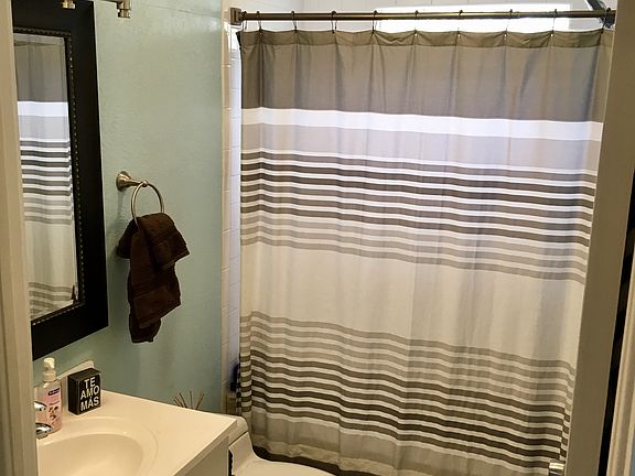 Bathroom has deep floor-to- ceiling cabinets behind the door