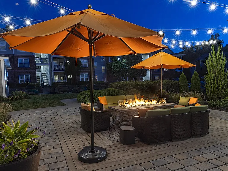 Outdoor lounge area with fire pit and cozy lighting