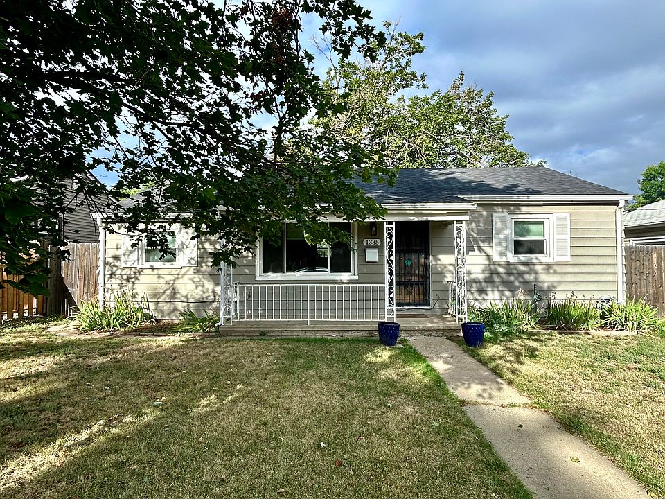 The house sits on a big front yard with a covered front porch.