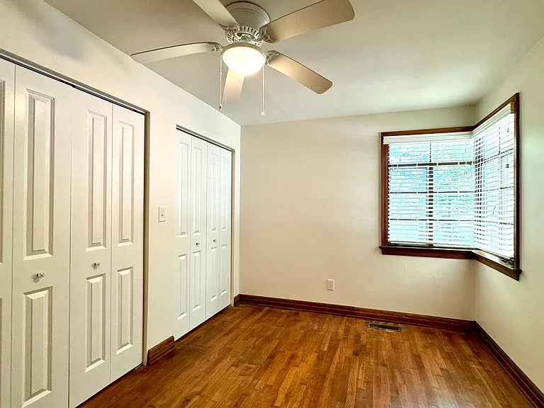 Bedroom 2 with hardwood flooring.