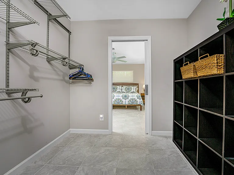 Primary bedroom walk-thru closet with access to the attached full bathroom
