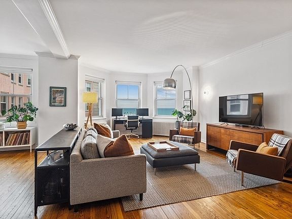 The living room features a bay window, oak floors