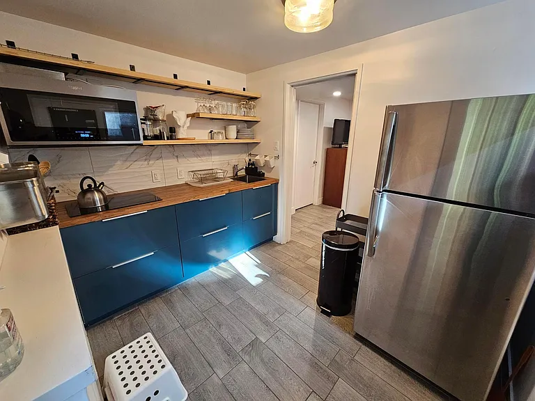 Kitchen view from front door entrance. Convection oven/microwave and electric cooktop.