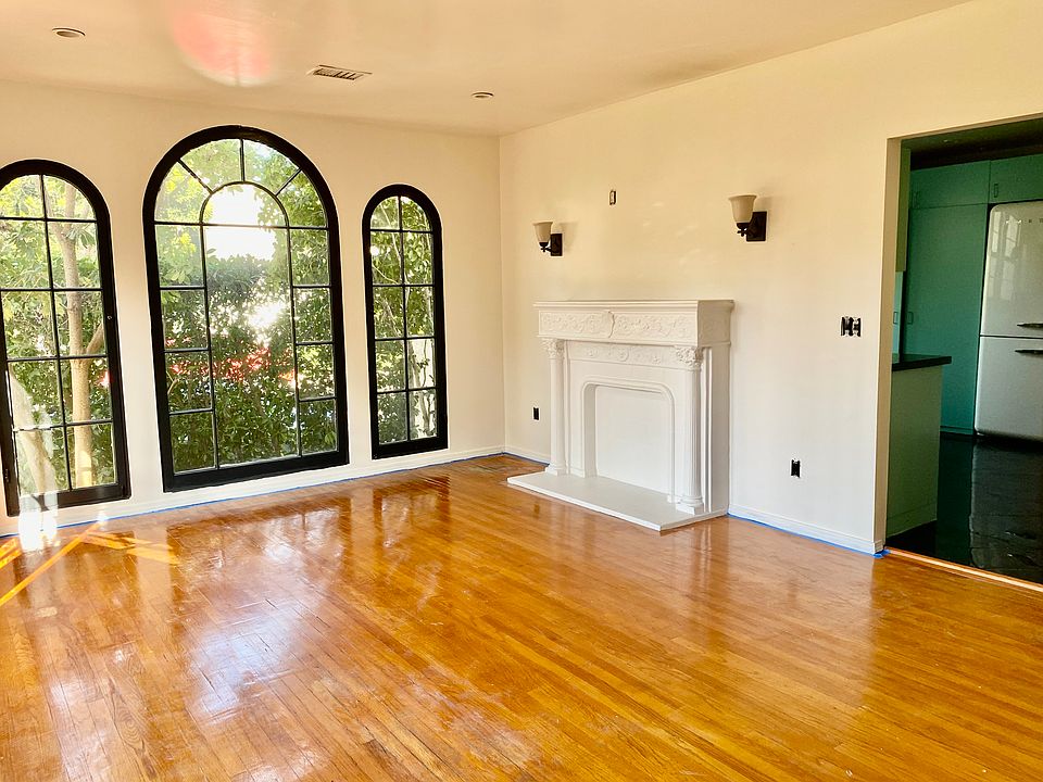 Decorative fireplace and windows. Door to kitchen