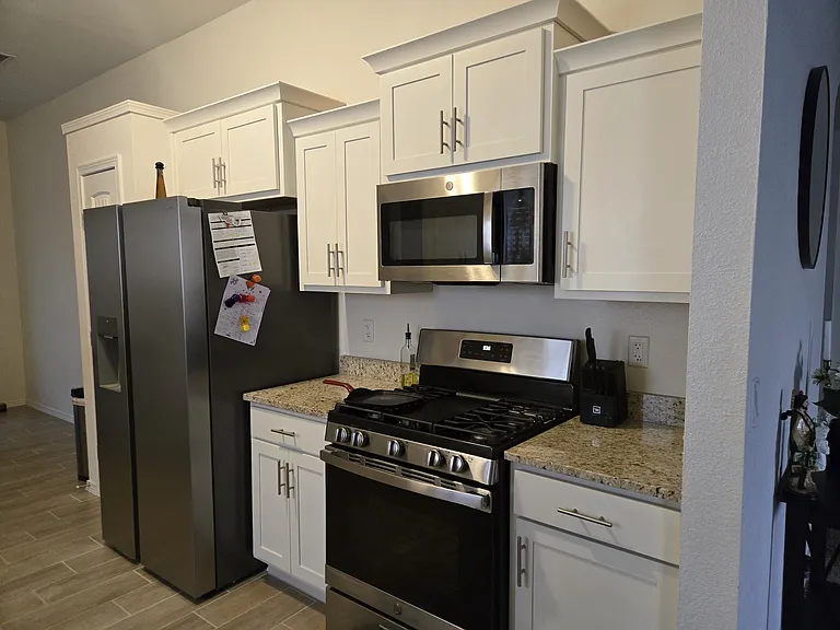 Modern kitchen with stainless steel appliances, granite countertops, and abundant storage.