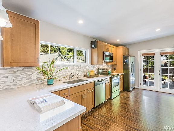 With a sparkling quartz countertop combined with bright tile backsplash, stainless steel appliances and gleaming laminate flooring under foot, this is a chef's dream of a kitchen.