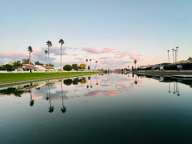 Breathtaking views of Lake Marguerite, serene water, swaying trees, lush lawns, and majestic mountains beyond...