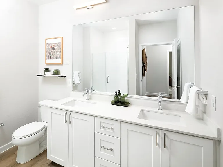 Finish Package I bath with white cabinetry, white quartz countertop, and hard surface flooring