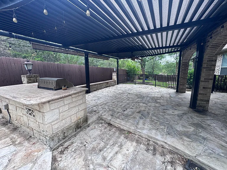 Large covered patio with pergola and built in grill.