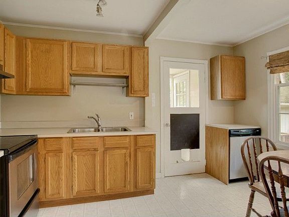Kitchen has ss appliances and track lighting. Door leads to utility room and door to back deck.