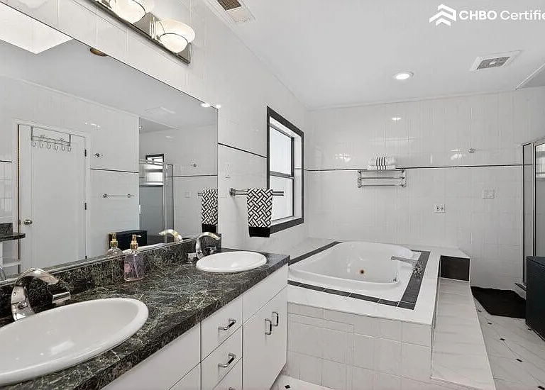 The primary bathroom features a large tub and shower