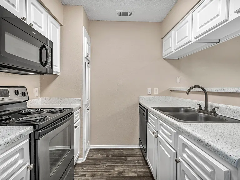 Modern kitchen with white cabinetry, refrigerator, and oven_ideal for everyday cooking.