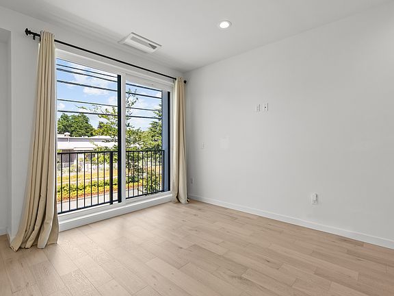 Living room features floor to ceiling slider and an abundance of light. Outlets designed for hidden cables.