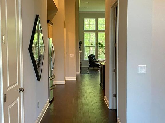 Hallway to open concept social area. Half bathroom on the right.